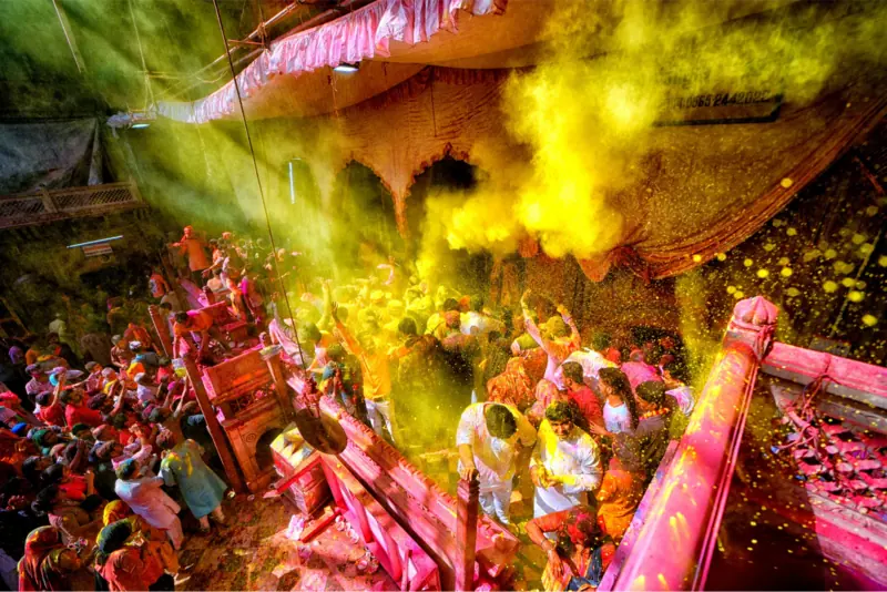 Holi celebration inside a Vrindavan temple, colours in the air